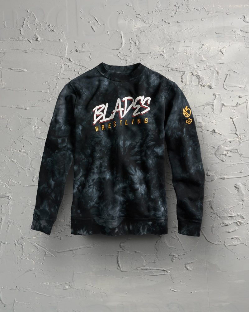 A stylish black tie-dye sweatshirt with bold white and yellow lettering that says BLADES WRESTLING