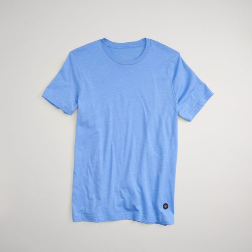 A light blue short-sleeve t-shirt laid flat against a neutral background featuring a minimalistic design with a circular logo at the hem