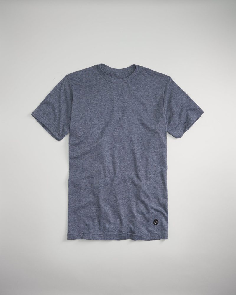 A heather navy t-shirt with short sleeves featuring a minimalistic design and a small logo near the bottom hem