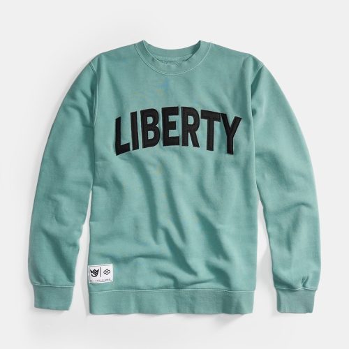 A mint green sweatshirt displaying the word LIBERTY in bold black letters across the chest with a small logo patch at the hem